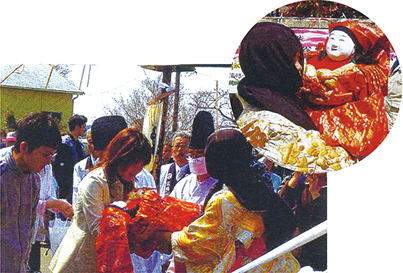 Women hug the sacred doll, Nennekosama