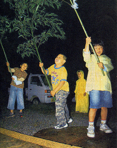 Children shake bamboo branches, praying for the good harvest of rice.